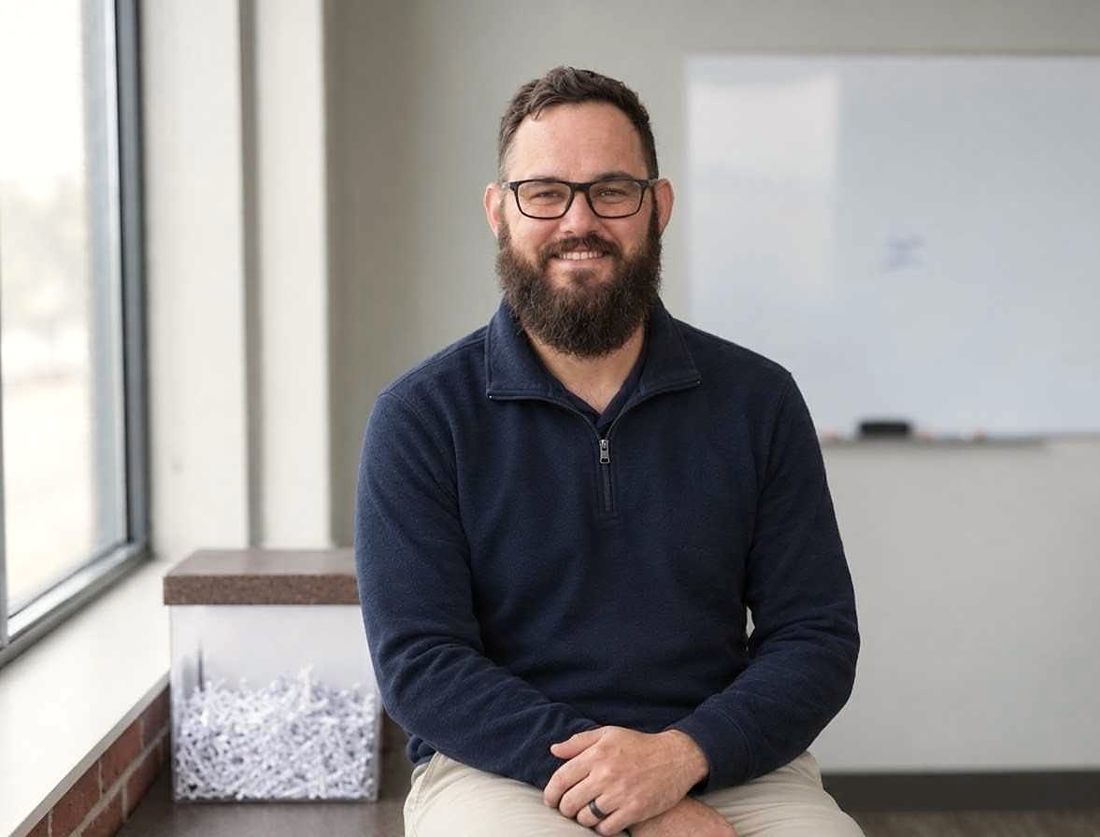 Collin Lawrence, President and Owner of Mid-Ohio Paper Shredding, seated beside a bin of shredded paper